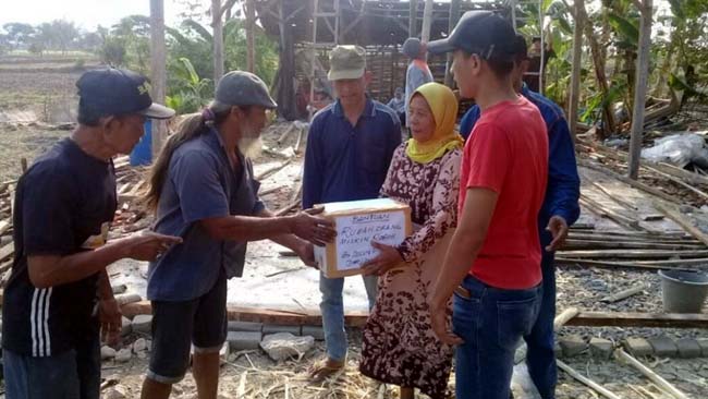 Mbah Poni (85) saat menerima santunan dari warga, atas musibah rumahnya yang ambruk